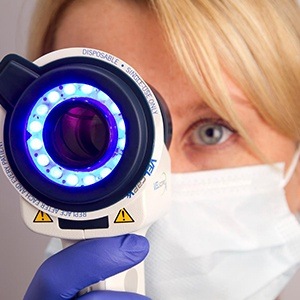 Dentist looking through oral cancer screening tool