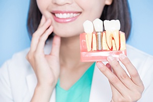 Dentist holding dental implant model