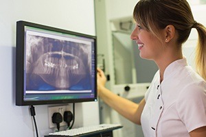 Dental assistant looking at d3ntal x-rays on computer
