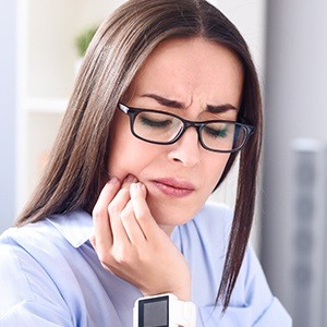 Woman holding jaw in pain