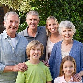 Three generations of family smiling outdoors