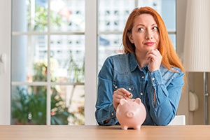 Woman putting a coin into a piggy bank