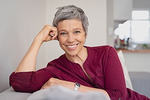 Woman with implant dentures in Lakewood smiling