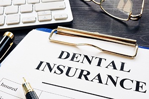 Dental insurance form lying on desk with glasses