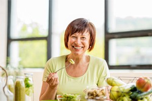 Woman eating with dental implants in Dallas 