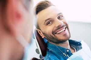 Patient with straight teeth smiling in treatment chair