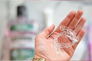 Hand holding two Invisalign trays