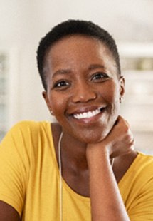 Woman in yellow shirt smiling in living room