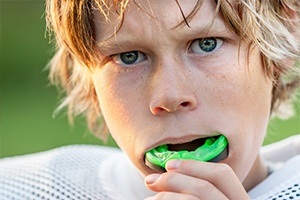 Teen boy placing sports mouthguard