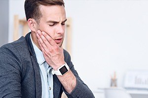 Man holding jaw in pain