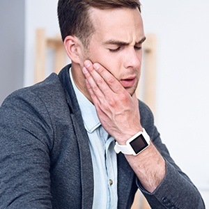 Man holding jaw in pain