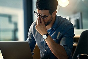 Frustrated man holding the bridge of his nose