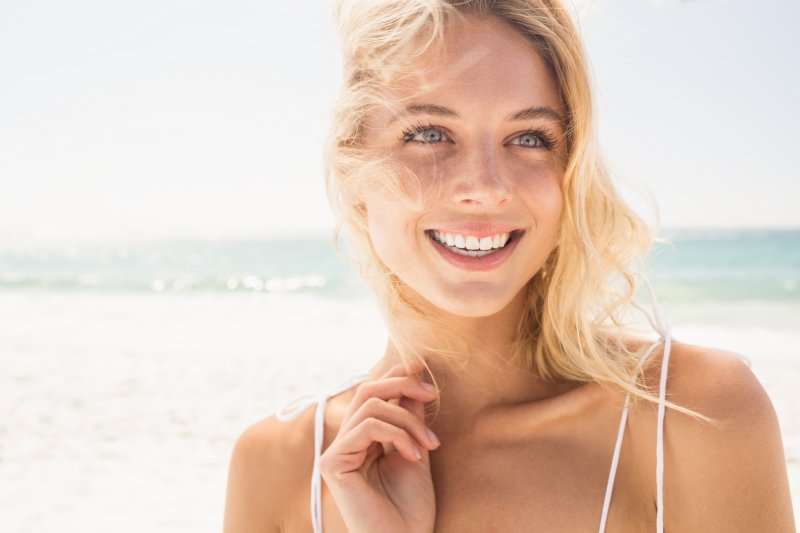 A woman smiling at the beach.