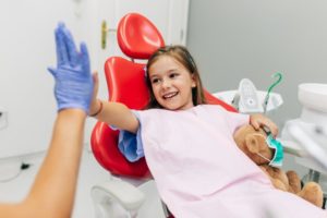 Young girl high-fives Lake Dallas sedation dentist