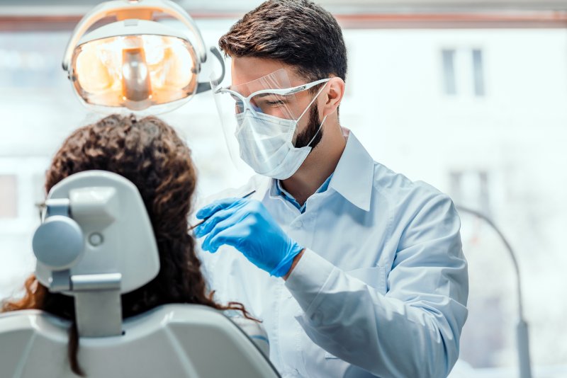 a male emergency dentist in Lake Dallas wearing PPE while caring for a patient