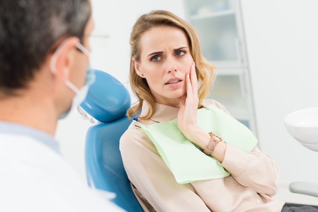 Woman looking concerned while talking to dentist