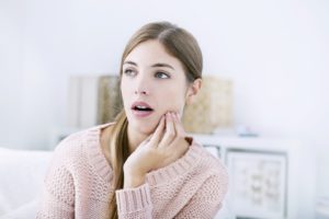 Woman with jaw pain, considering dental implants in Lakewood, Dallas