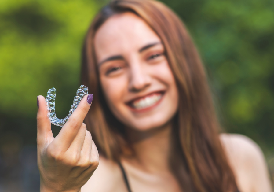 Woman holding Invisalign up to camera