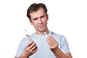 man looking at toothbrushes